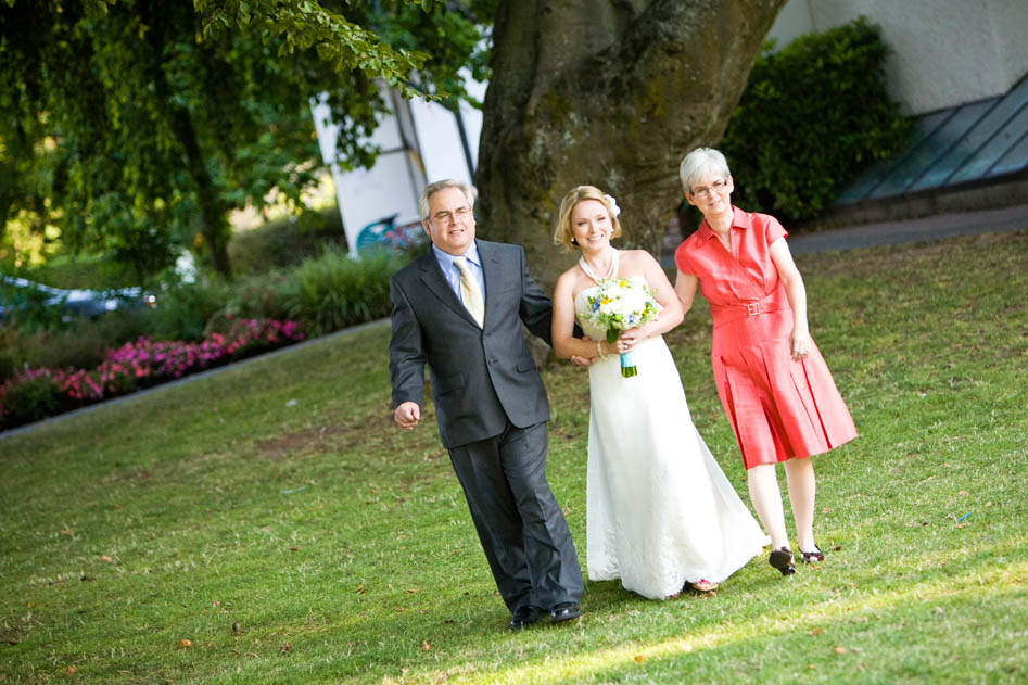 bride entering ceremony with parents at brock house wedding in Vancouver