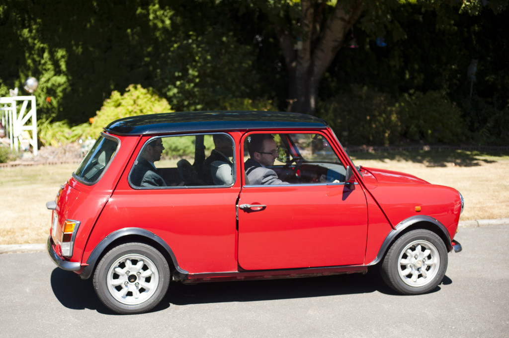 groom and groomsmen travel to wedding in vintage mini