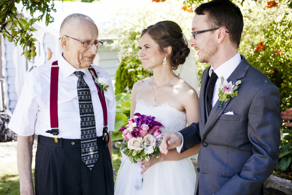 bride and groom with grandfather after wedding ceremony