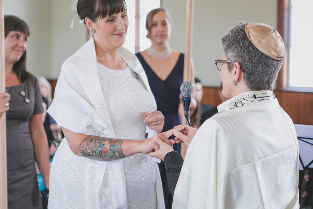 exchanging rings at same-sex jewish wedding ceremony vancouver, tattooed bride