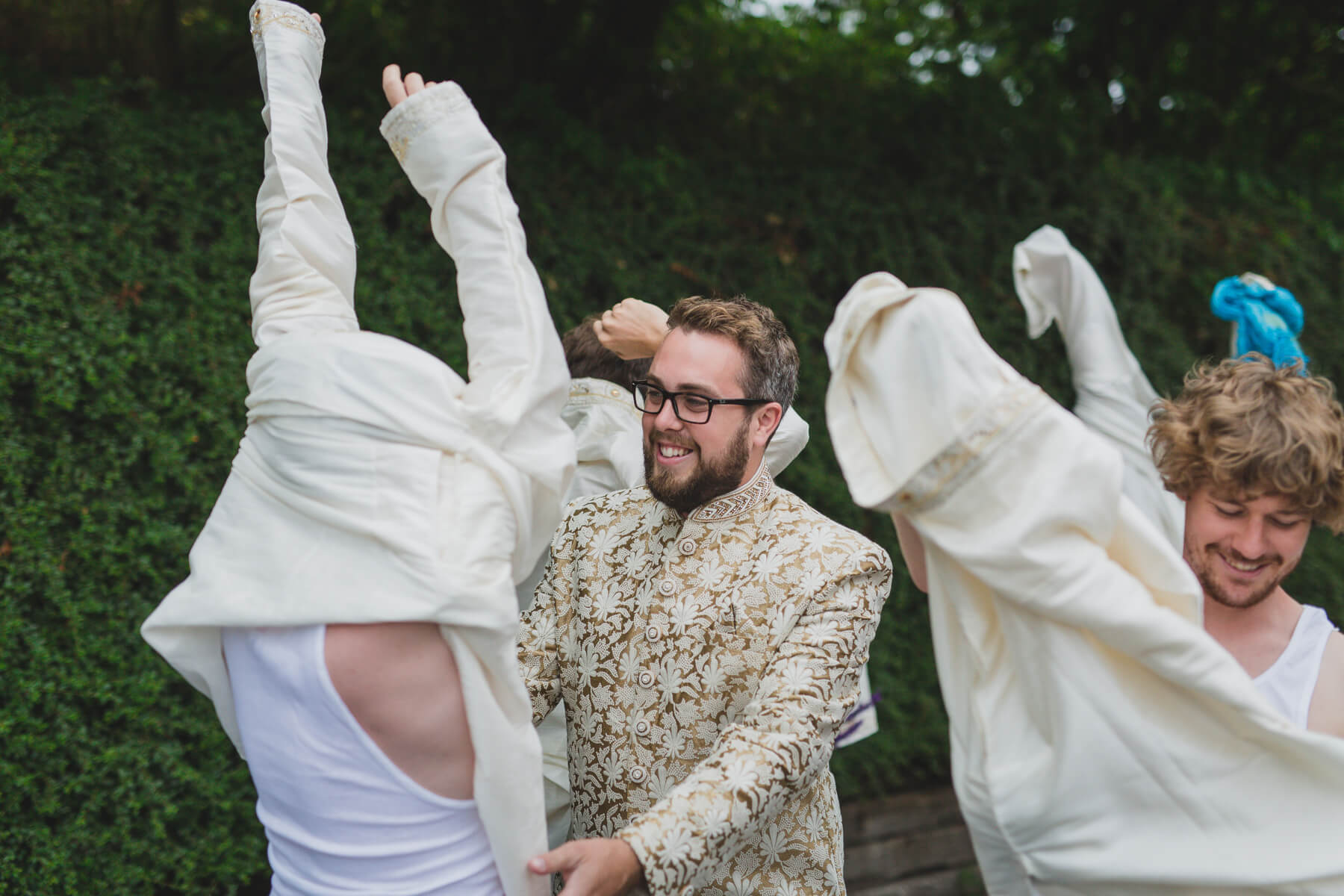 groom helping groomsmen get ready