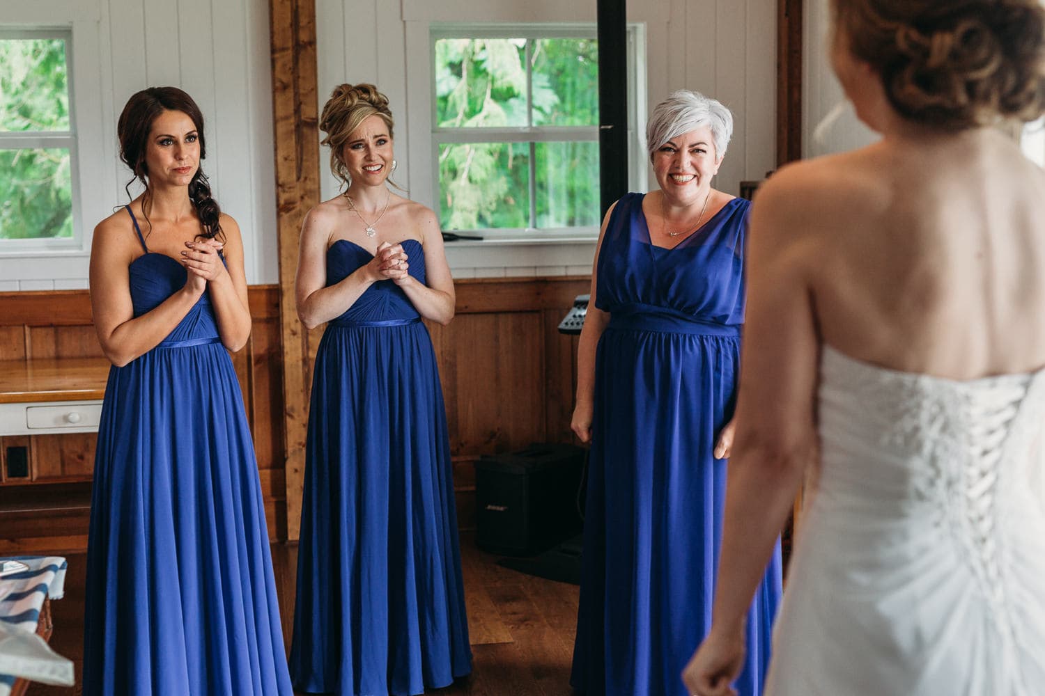 excited bridesmaids seeing bride at heronsbridge getting ready suite