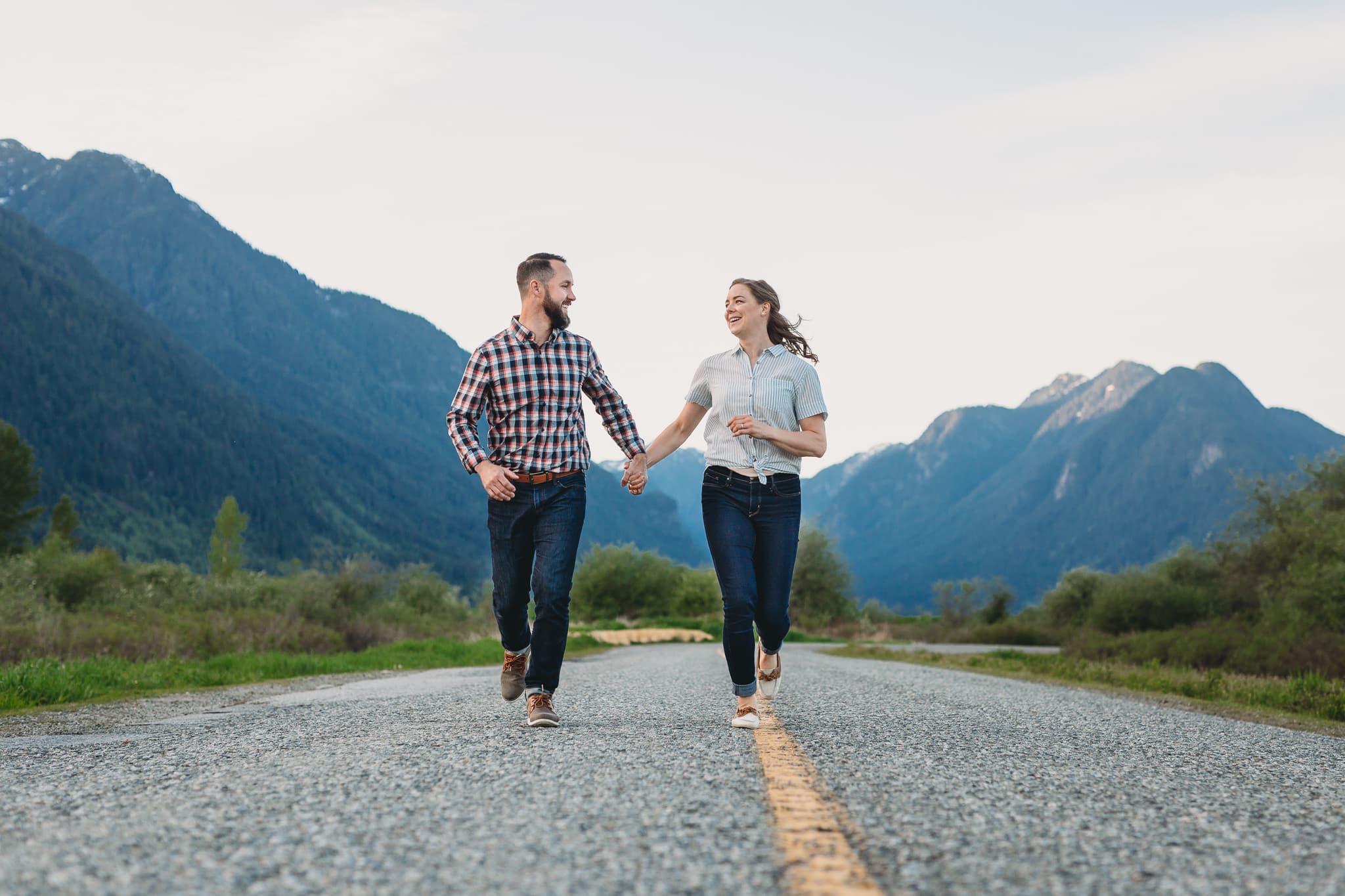 couple running down the road in pitt meadows at offbeat engagement session