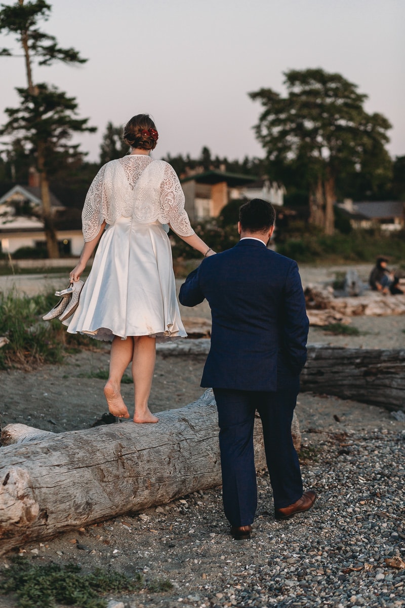 couple walking shoeless on beach at relaxed casual wedding