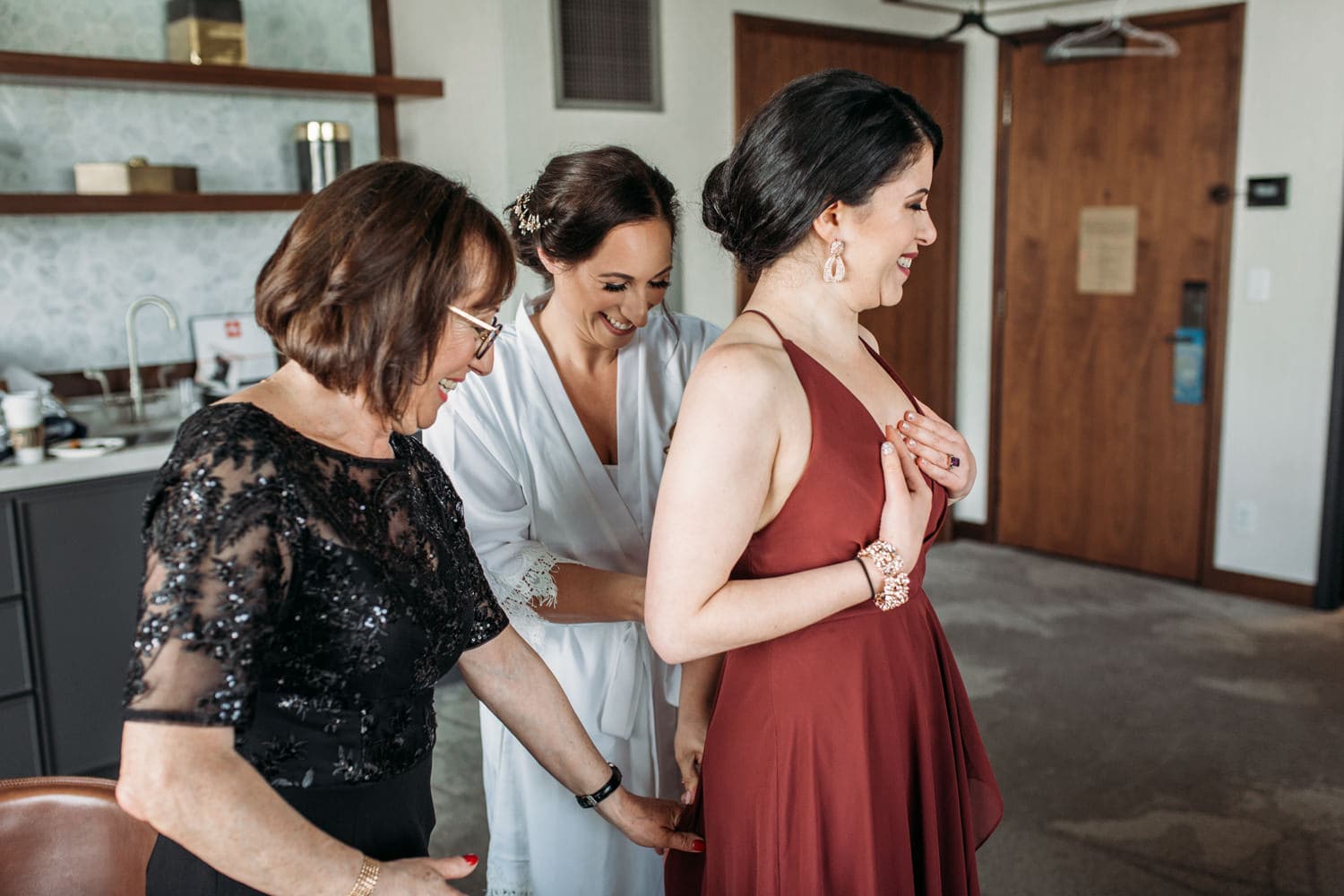bride helping bridesmaid get ready at the douglas hotel in vancouver
