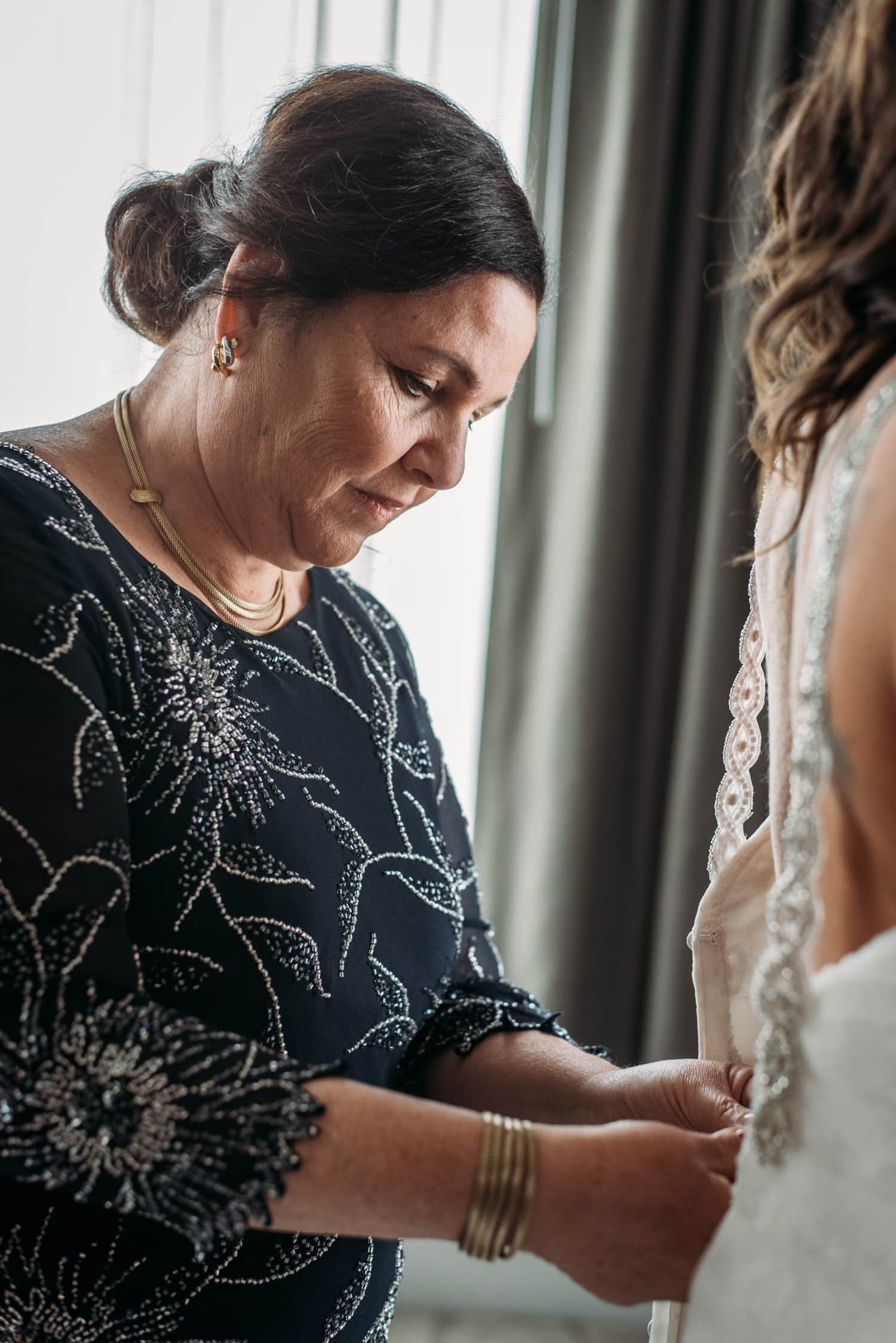 bride's mom zipping up wedding dress at lgbtq wedding in vancouver