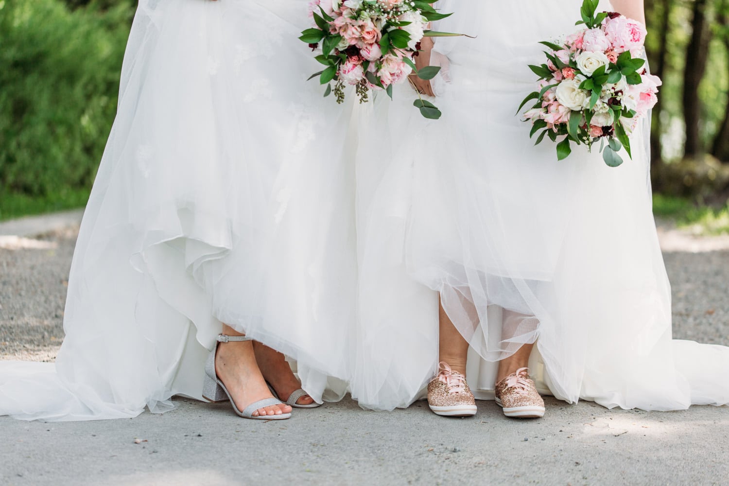 two brides feet in wedding dresses with flowers at vancouver wedding