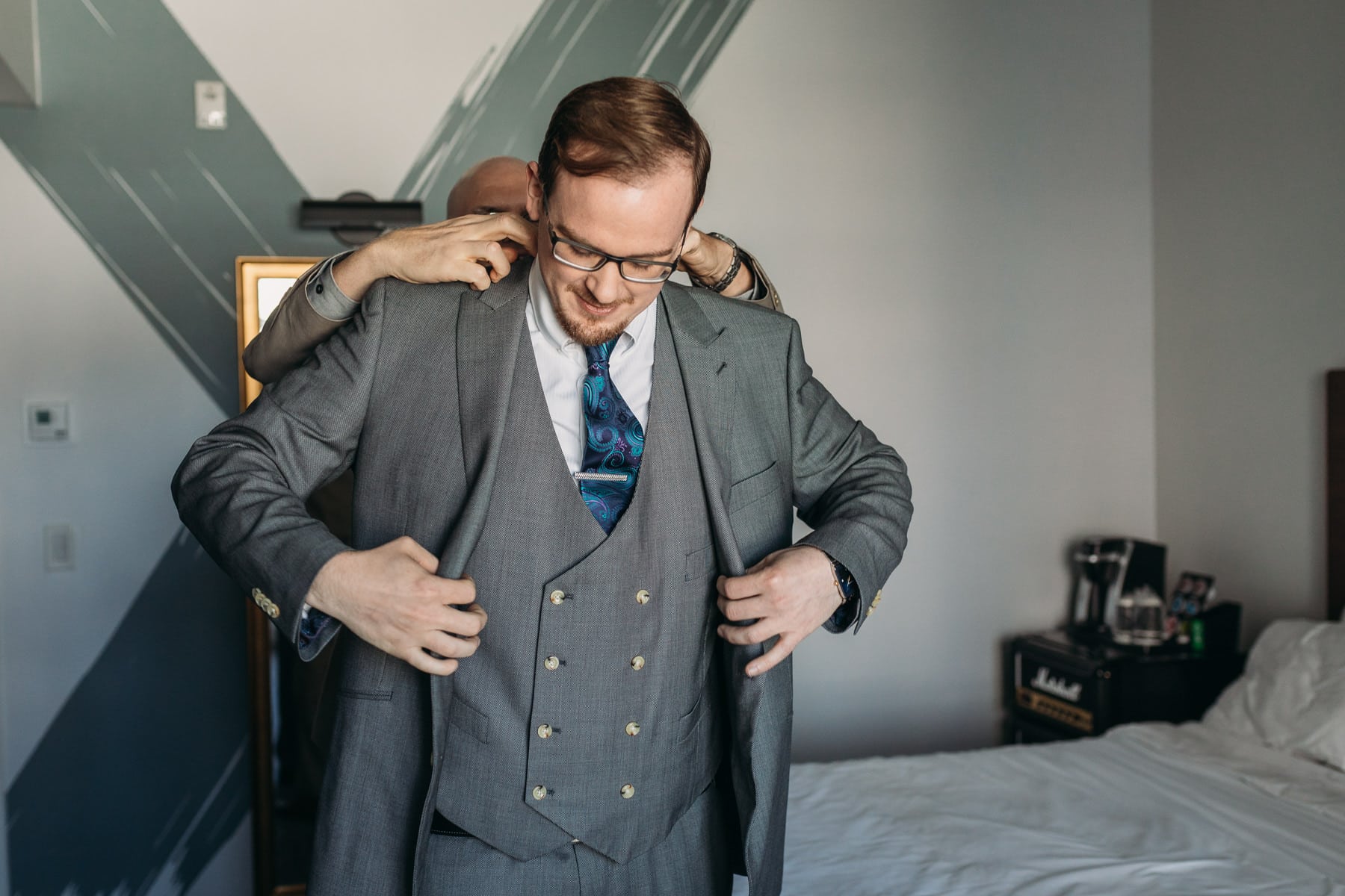 Groom prep putting on Indochino suit for wedding day at Hotel Belmont Vancouver