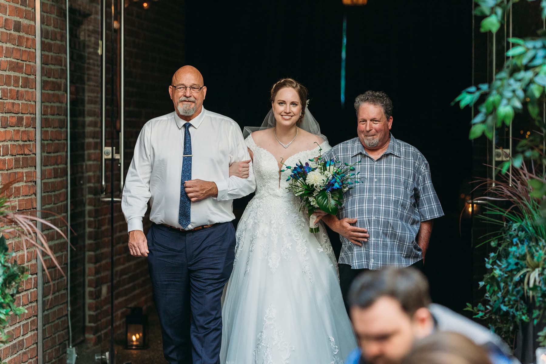 bride walking down the aisle with two dads at Brix Vancouver wedding ceremony