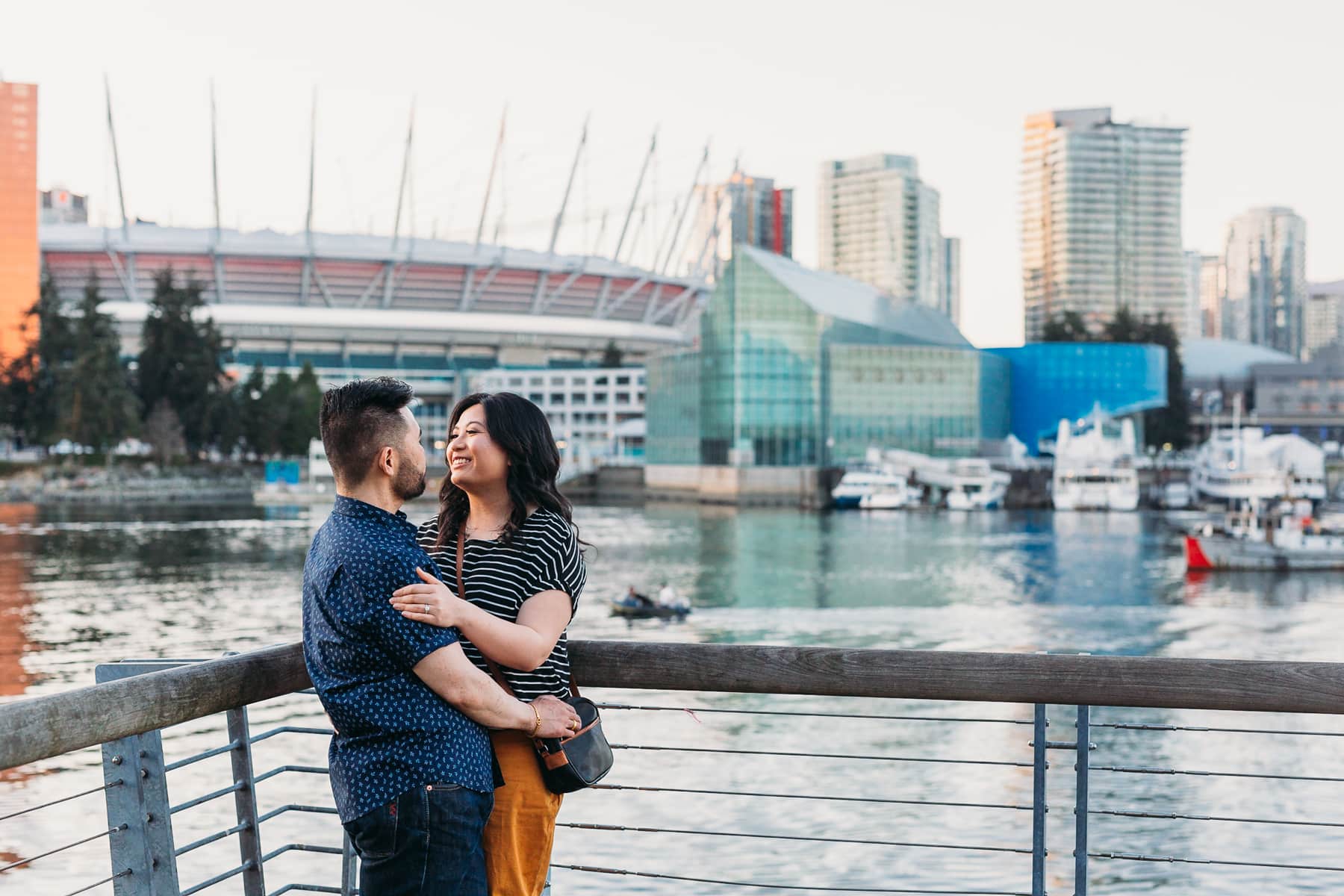 couple cuddling at olympic village engagement session in vancouver