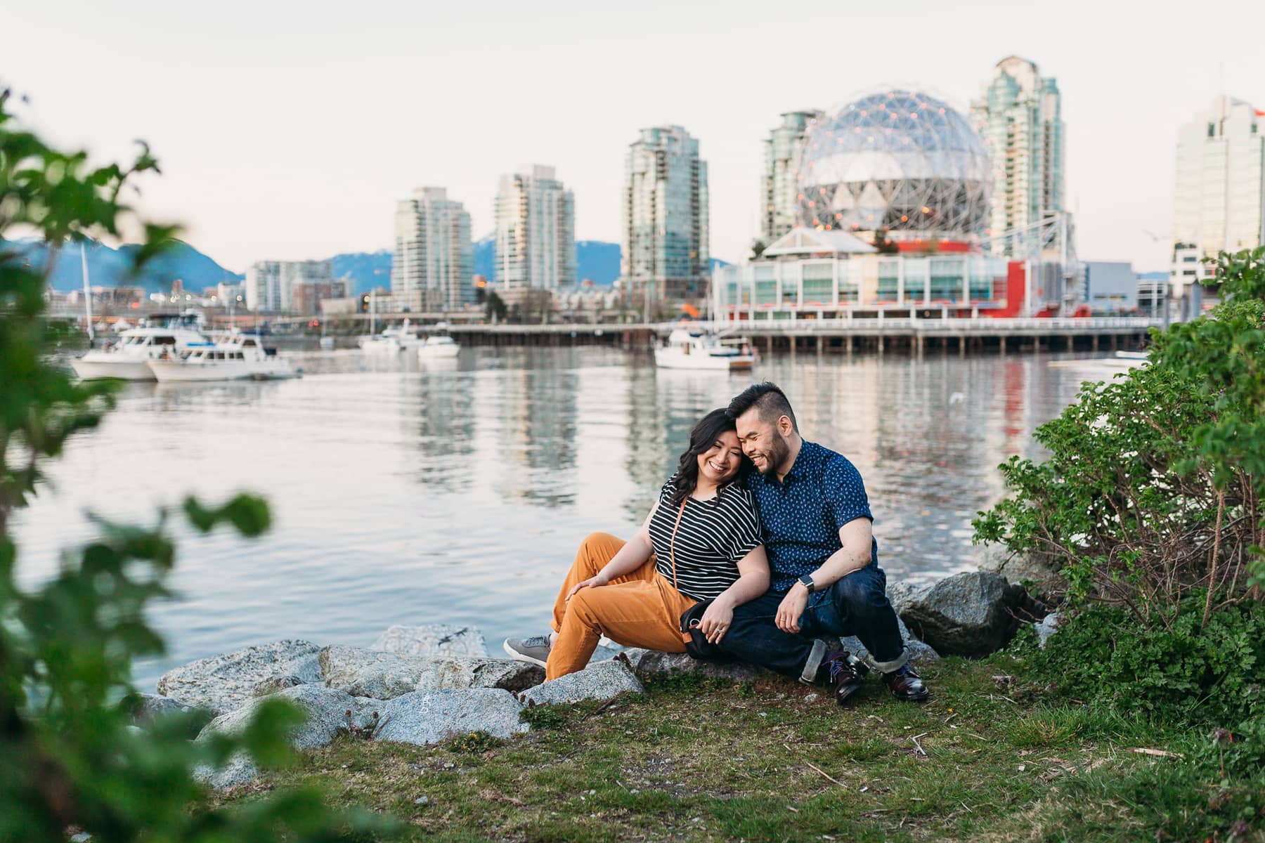 couple cuddling in front of Science World in False Creek Vancouver